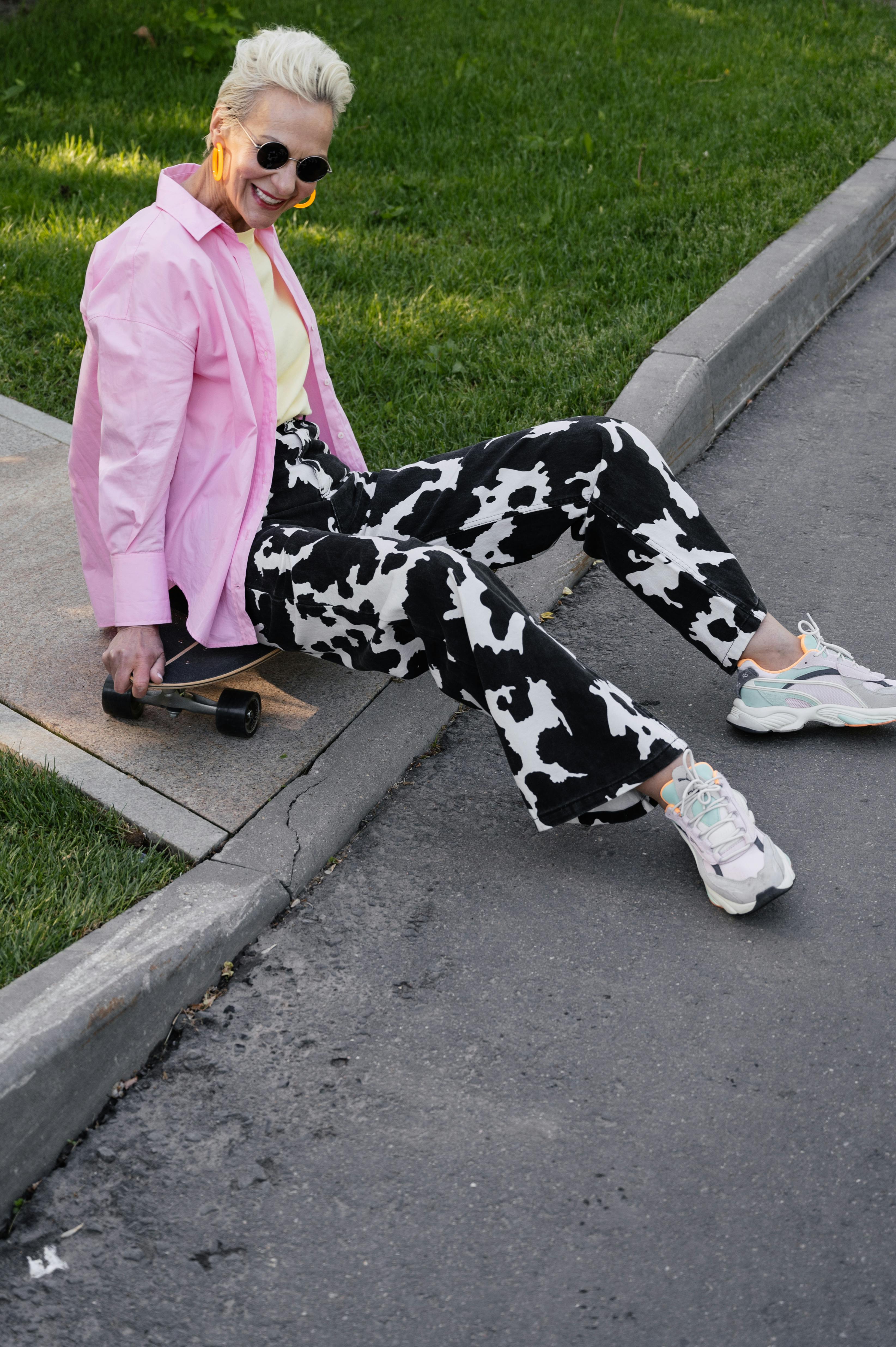 smiling woman sitting on a skateboard