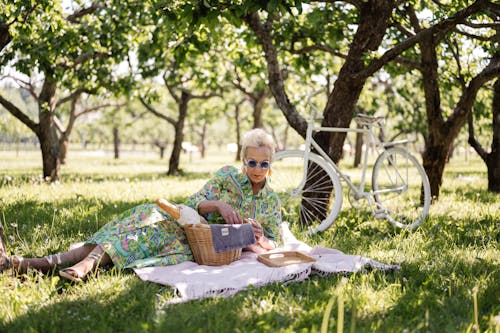 Elderly Woman Having a Picnic in Grass Field