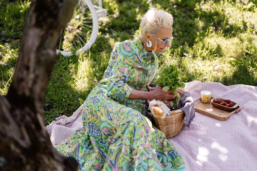 Free Elderly Woman Having a Picnic in Grass Field Stock Photo