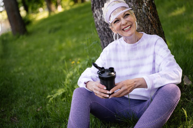 Elderly Woman Smiling While Holding A Tumbler