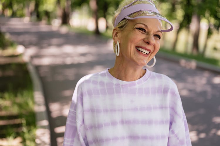 An Elderly Woman With Lavender Hat Smiling 