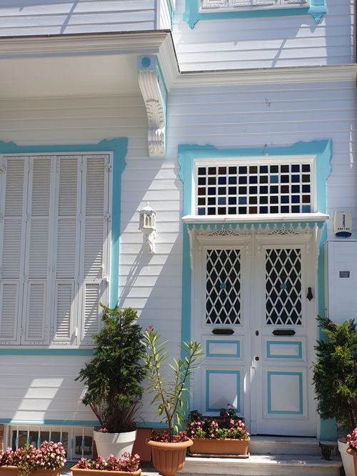 Free Elegant facade of a house with decorative door and potted plants. Stock Photo