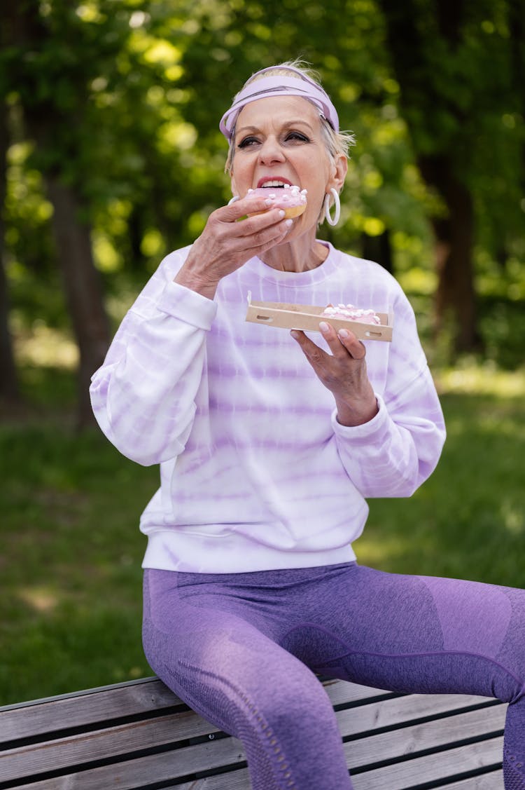 Woman In Purple Sweater Eating Donut