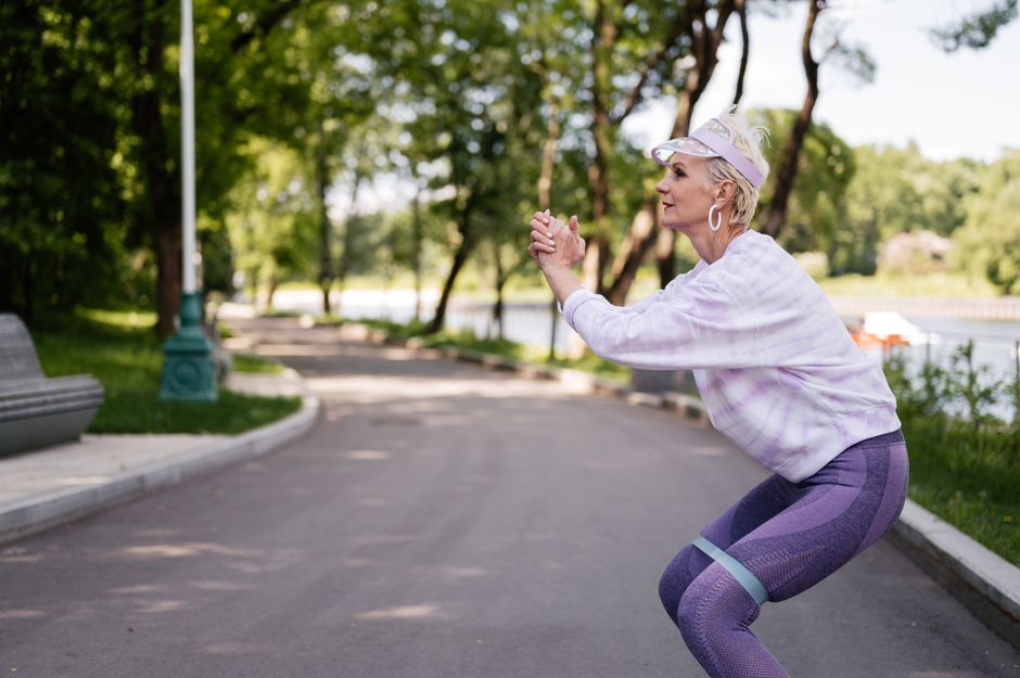 woman performing a banded squat exercise woman performing a banded squat exercise