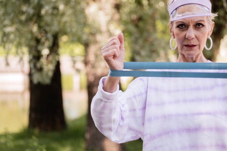 An Elderly Woman Exercising With A Resistance Band