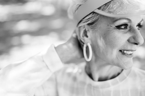 Free A smiling senior woman with an earring, captured in a classic black and white close-up portrait. Stock Photo