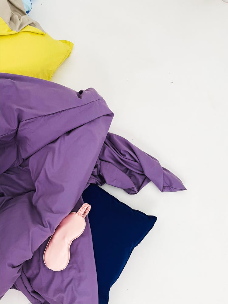 Purple Bedsheets And A Sleeping Mask 