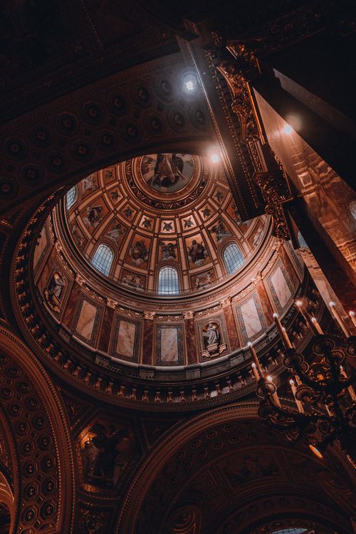 Free Low angle view of an intricately decorated cathedral dome, showcasing detailed religious artistry. Stock Photo