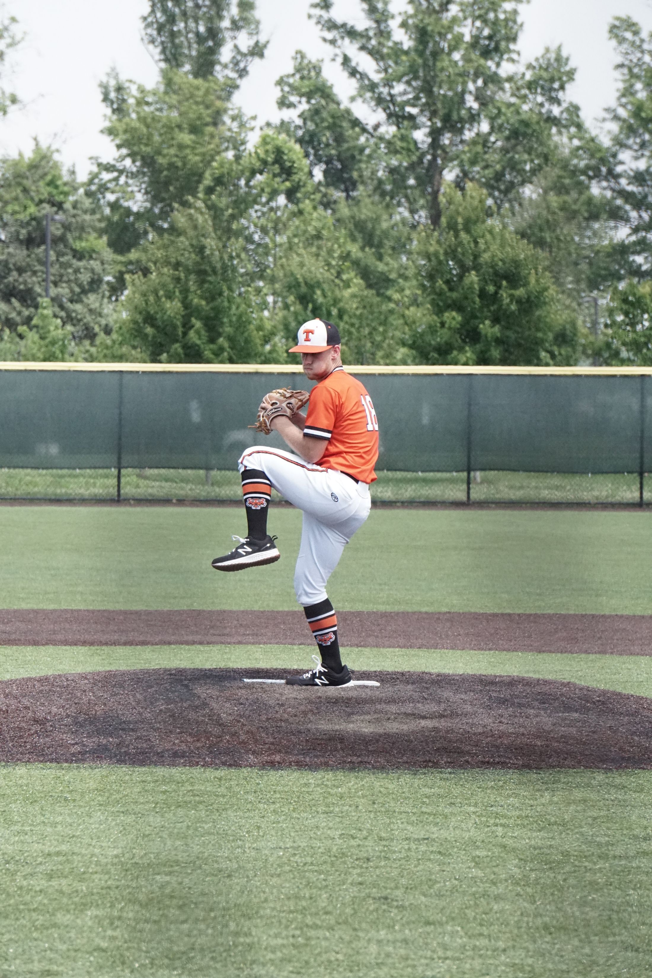 Baseball pitcher driving through an athletic pitching motion