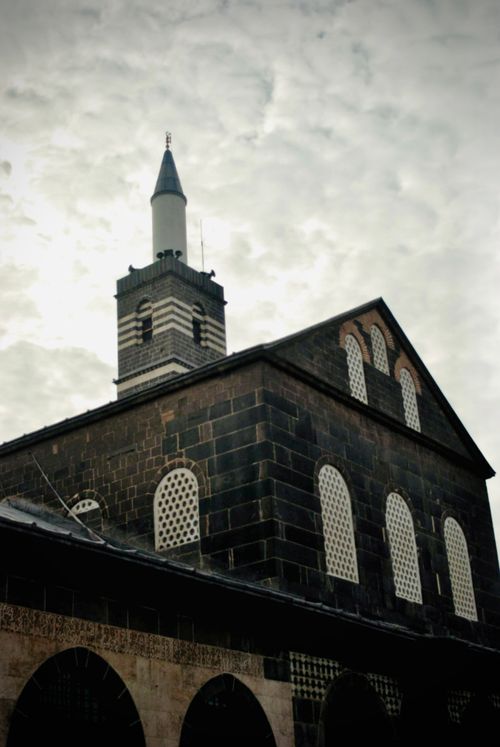 Free Captivating architecture of the Diyarbakır Ulu Camii mosque showcasing a dramatic cloudy sky. Stock Photo