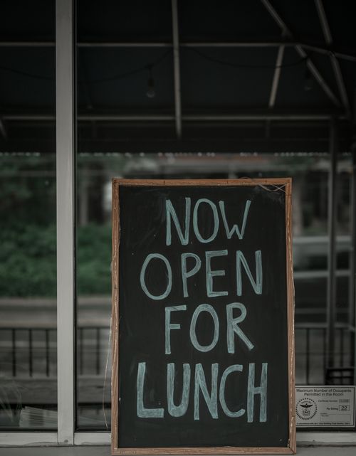 Free A chalkboard sign outside a restaurant stating 'Now Open for Lunch'. Stock Photo