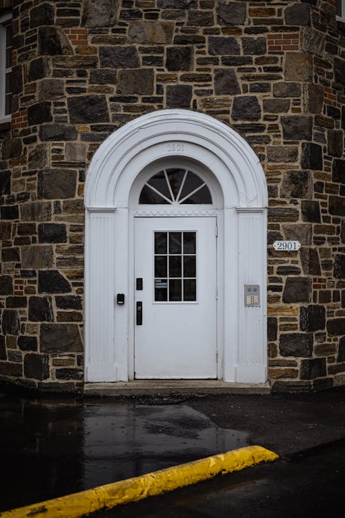 White Wooden Door on Brown Brick Wall