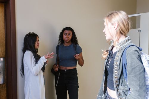Free Three teenagers engage in a tense conversation indoors, capturing peer interactions. Stock Photo