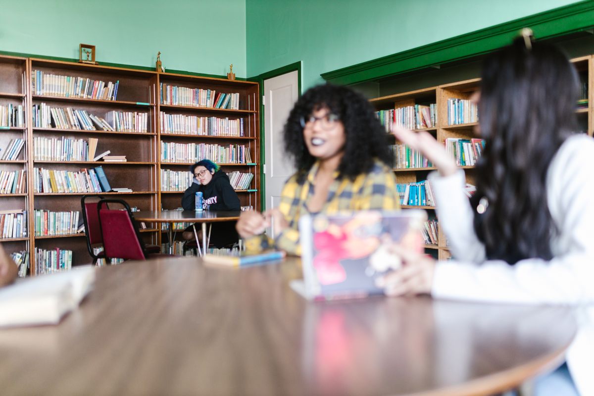 Elevi pregătindu-se pentru un examen de limbă în bibliotecă