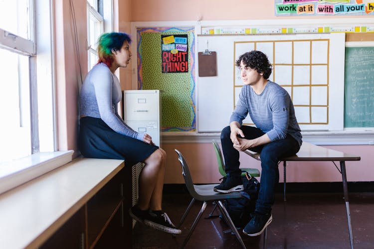 A Man And Woman Talking In Classroom