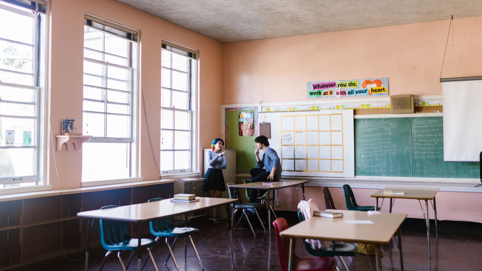 Two older students discussing a task in an English classroom, representative of B1 and B2 CEFR level speaking practice