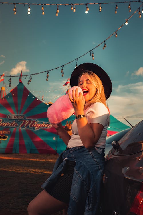 Happy Woman Eating Cotton Candy at a Festival 