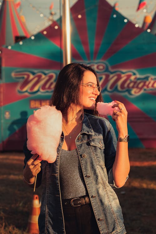 A Pretty Woman in Denim Jacket Eating a Cotton Candy