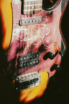 Close-up of a vintage electric guitar showcasing strings and unique scratchboard design.