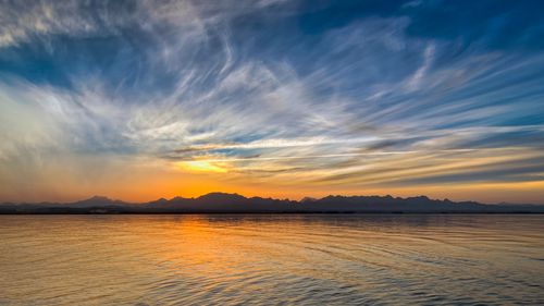 Free A stunning sunrise over calm ocean waters, perfect for peaceful and serene themes. Stock Photo