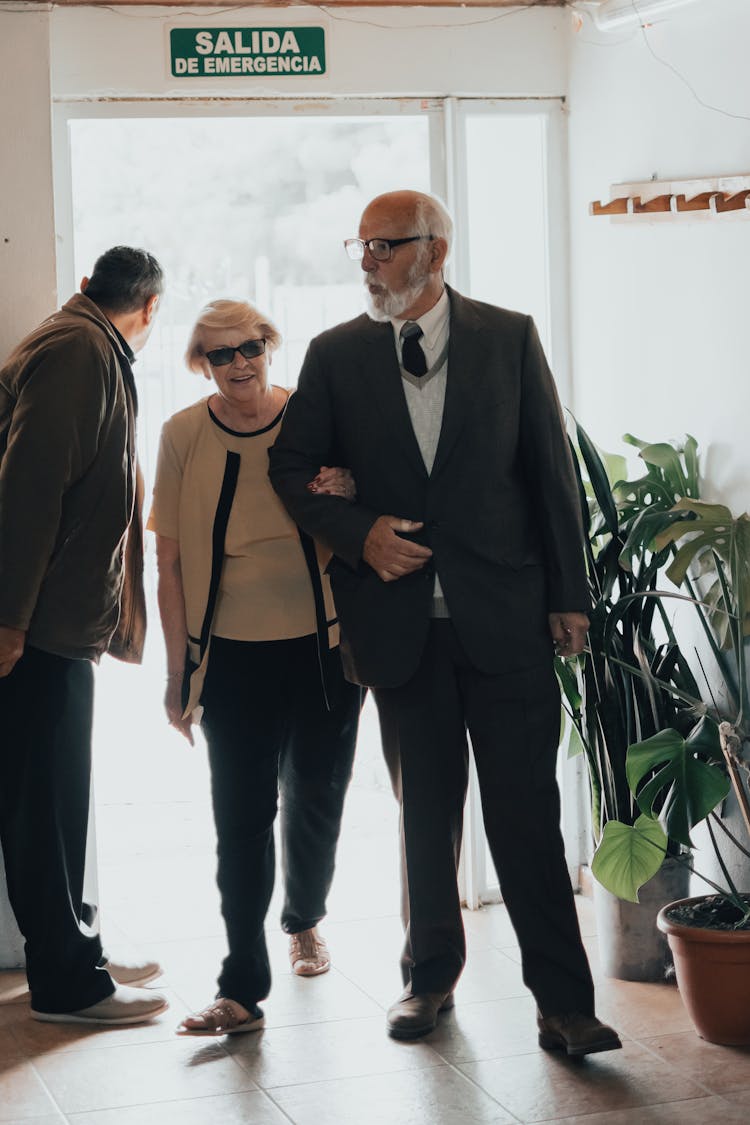 An Elderly Couple Walking Indoors