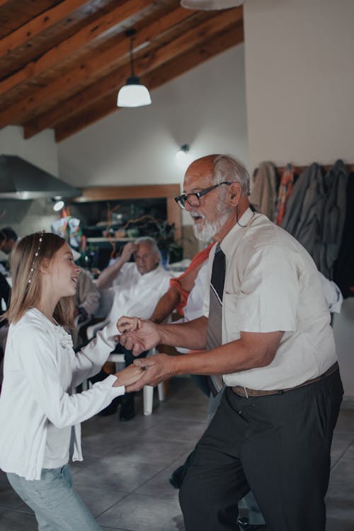 An Elderly Man Dancing with His Grandchild