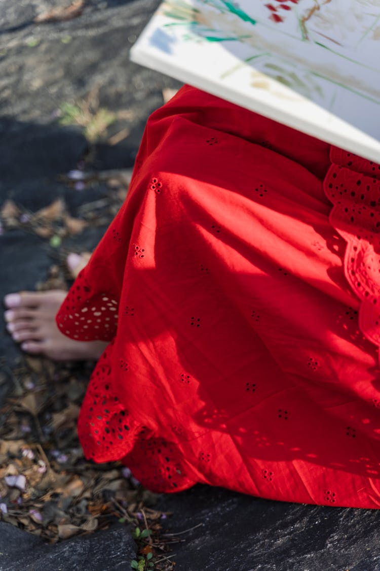 A Barefoot Person In A Red Skirt