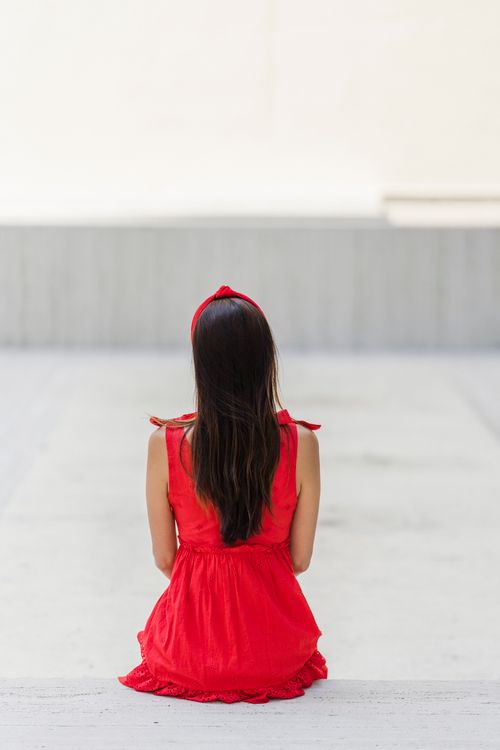 in a red dress and alone Queen In Long Red Dress With Magnificent Lush Train Woman Walks Alone Through Scarlet Autumn Forest Gold Crown And Necklace On Light Body Royal Charm And Majesty Sun Rays Make Through Bare