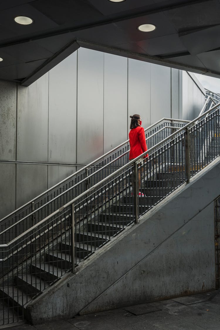 A Person In A Red Blazer Standing On The Stairs