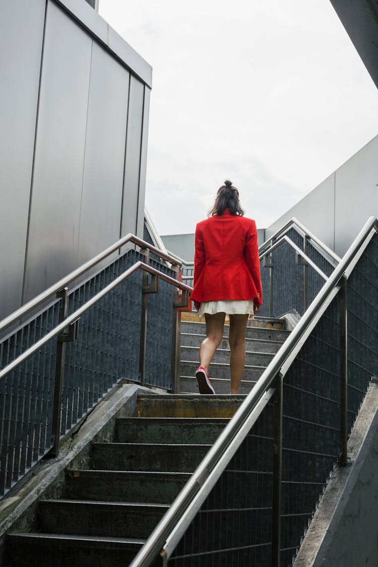 Woman In Red Blazer Ascending The Stairs