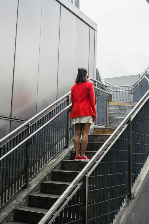 Woman in Red Suit Climbing the Stairs