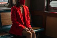 Woman in Red Blazer Sitting on Black Leather Chair