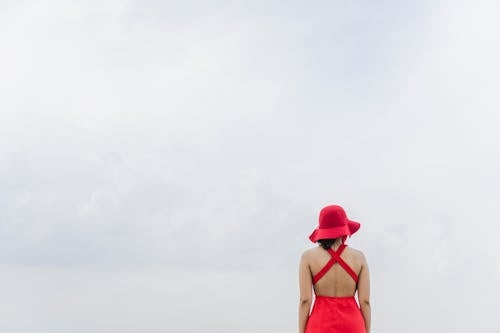 Woman Wearing Red Dress and Hat Looking at View