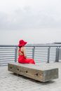 Woman in Red Hat Sitting on Brown Wooden Bench