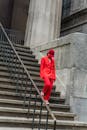 Person in Red Blazer and Red Pants Walking on Concrete Stairs