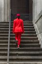 Person in Red Blazer and Red Pants Walking on Concrete Stairs