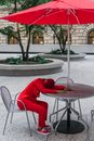 Person in Red Hoodie Sitting on Chair