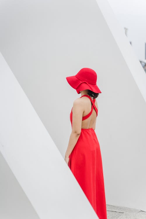 Free A Woman in Red Dress Standing while Wearing a Red Bucket Hat Stock Photo