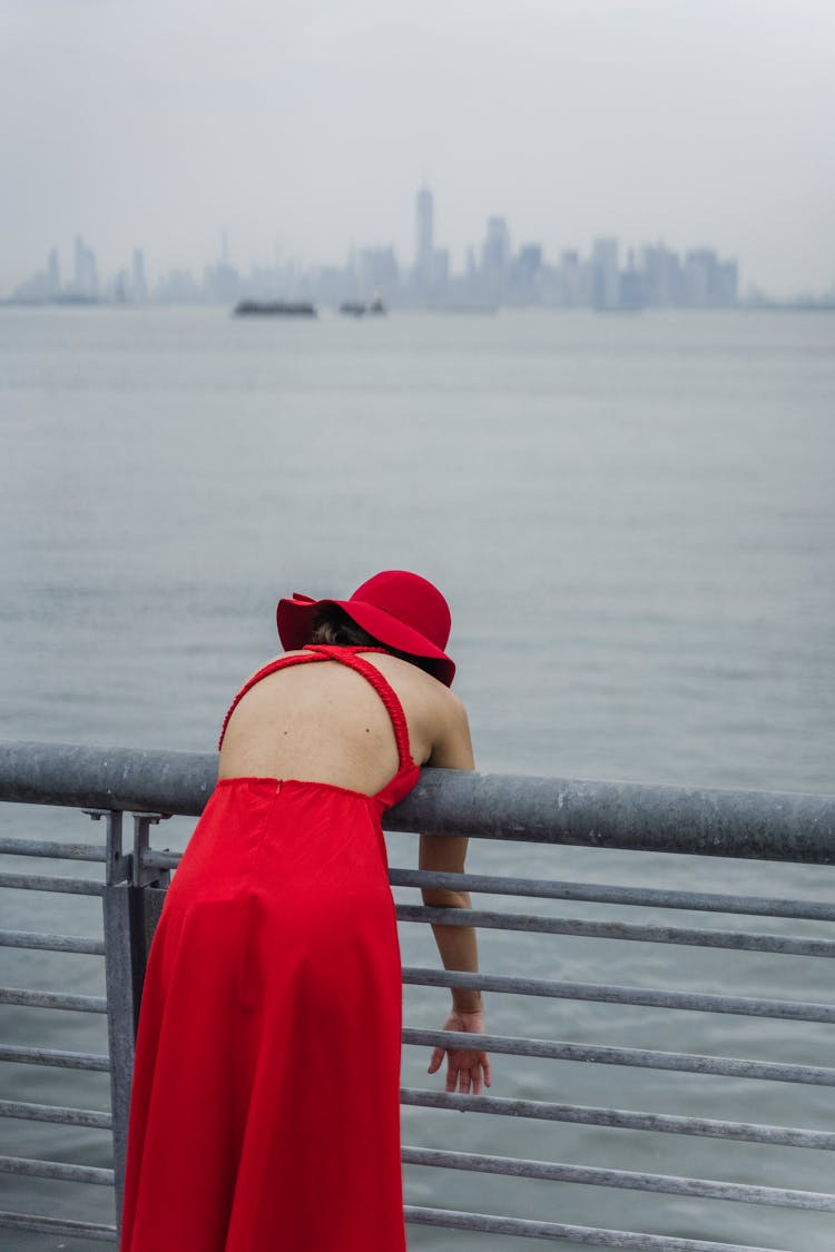 Woman Leaning On Barrier On Sea Shore In City