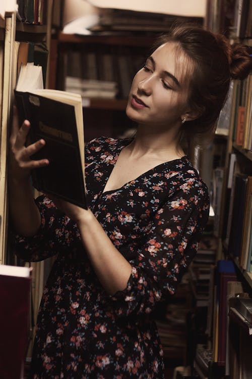 Free Woman in Floral Dress Reading a Book Stock Photo