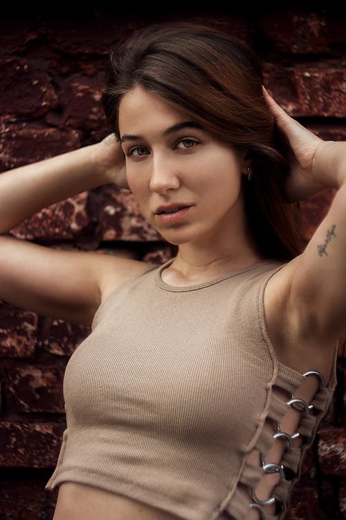 A Beautiful Woman in Beige Tank Top with Her Hands on Her Head