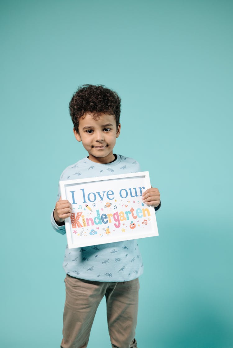 Photo Of A Boy Holding A Placard