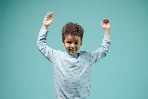 Free Boy in Blue Sweatshirt Raising His Hands Stock Photo