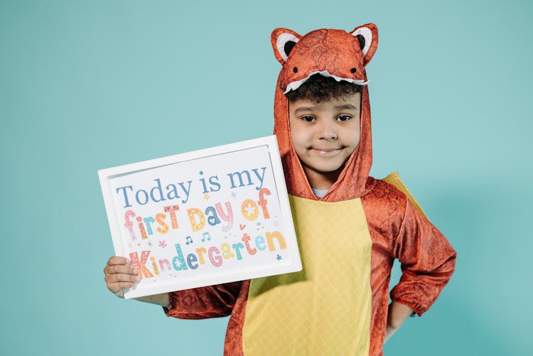 A Boy In An Animal Costume Holding A Poster