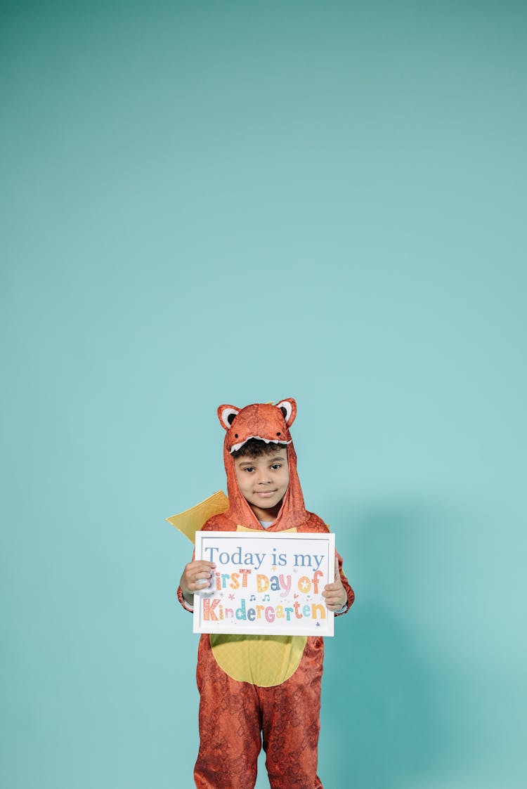 Boy In Orange Animal Costume Holding White Picture Frame