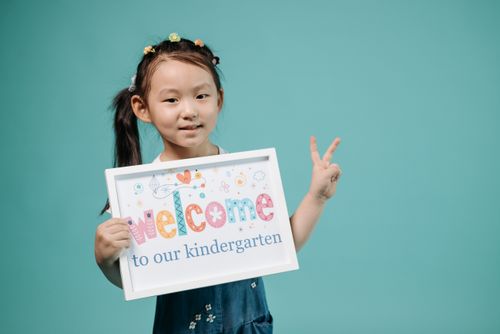 Free Cute child posing with welcome sign in a studio setting. Stock Photo