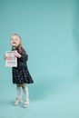 Girl in Black and White Polka Dot Long Sleeve Dress Holding White and Red Book