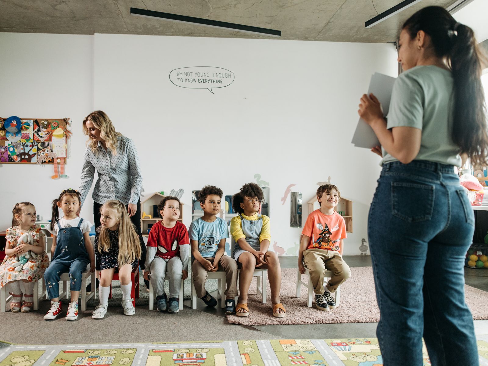 An early-years educator with children in a bright learning room