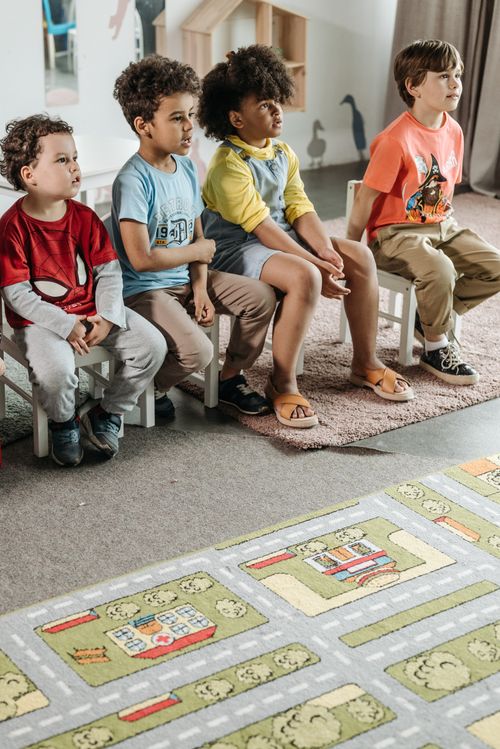 Free Children sitting in a classroom, showcasing diversity and early education engagement. Stock Photo