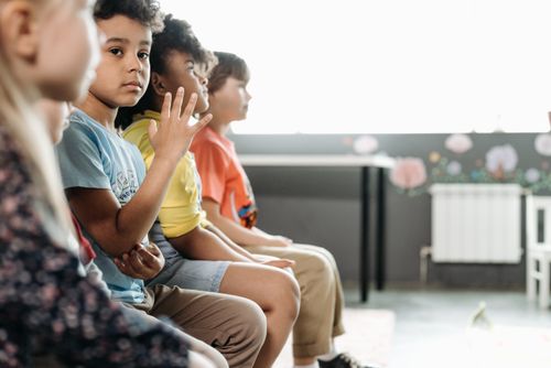 Free Children of diverse backgrounds sitting in a classroom, capturing innocence and togetherness. Stock Photo